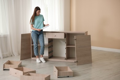 Photo of Woman with manual assembling furniture at home