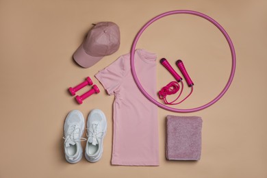 Photo of Sportswear, sports equipment and towel on beige background, flat lay