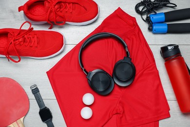 Photo of Flat lay composition with sportswear and headphones on floor