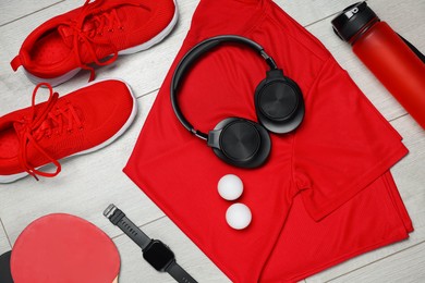 Photo of Flat lay composition with sportswear and headphones on floor
