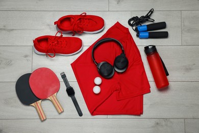 Photo of Flat lay composition with sportswear and headphones on floor
