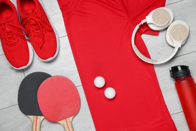 Photo of Flat lay composition with sportswear and headphones on floor