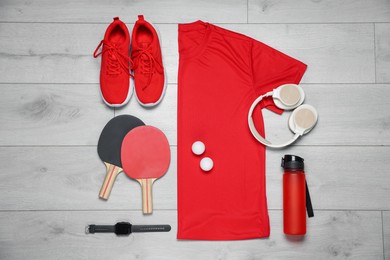 Photo of Flat lay composition with sportswear and headphones on floor