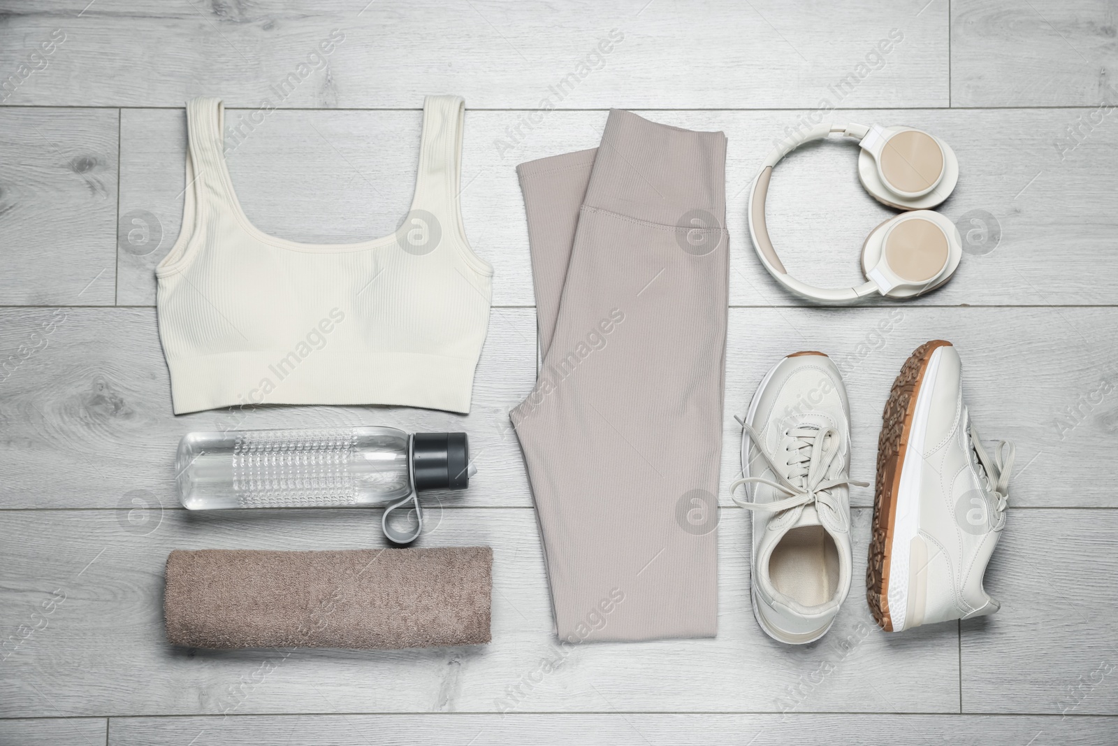 Sportswear, sneakers, water bottle and towel on floor, flat lay Photo of Sportswear, sneakers, water bottle and towel on floor, flat lay