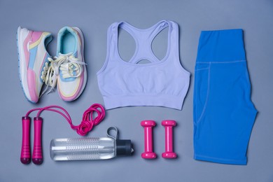 Photo of Sportswear, sneakers, skipping rope, dumbbells and water bottle on grey background, flat lay