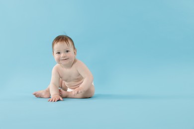Photo of Cute little baby crawling on light blue background. Space for text