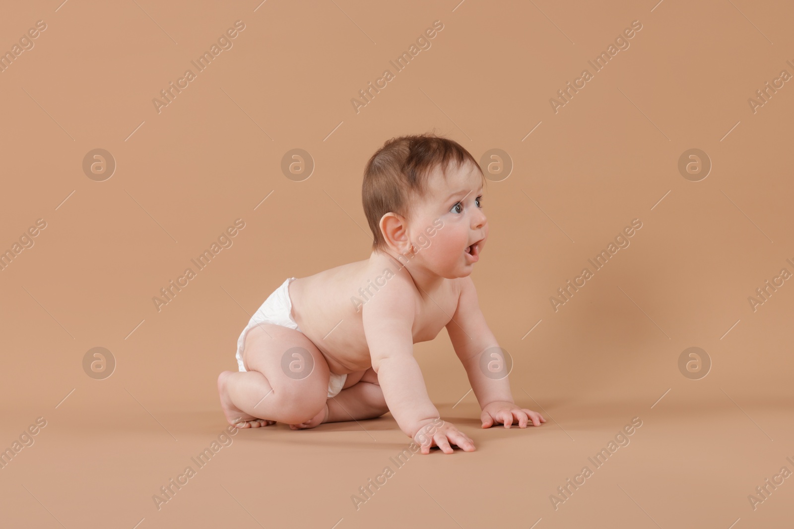 Cute little baby crawling on beige background Photo of Cute little baby crawling on beige background