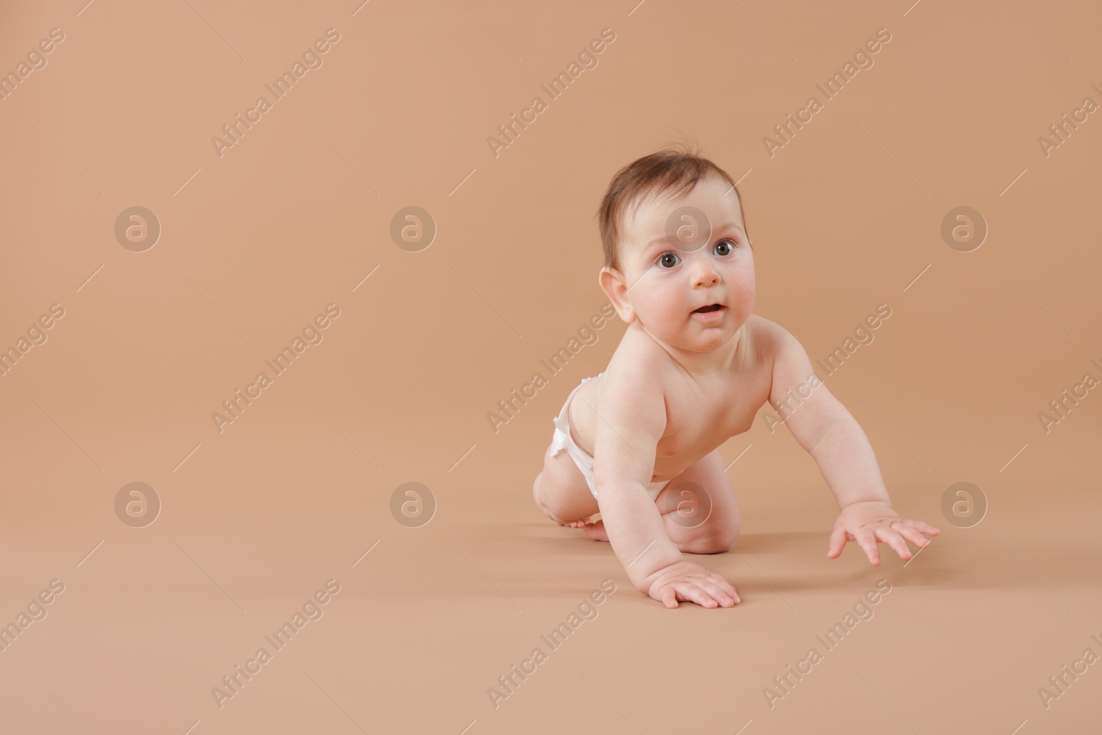 Cute little baby crawling on beige background. Space for text Photo of Cute little baby crawling on beige background. Space for text