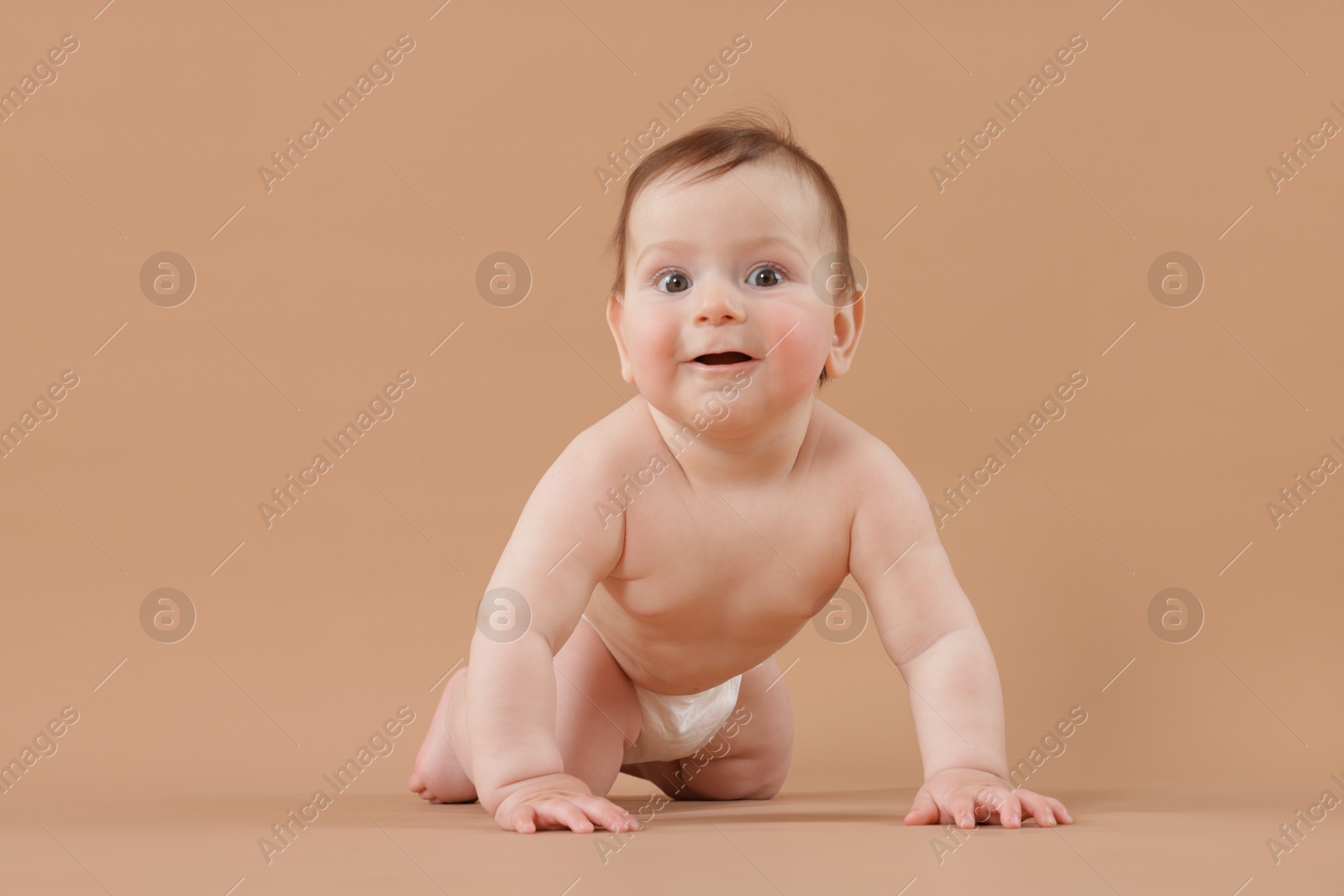 Cute little baby crawling on beige background Photo of Cute little baby crawling on beige background
