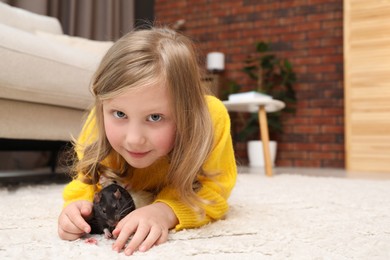 Photo of Little girl with cute rats on floor at home, space for text