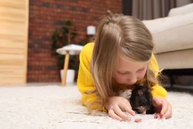Photo of Little girl with cute rats on floor at home, space for text