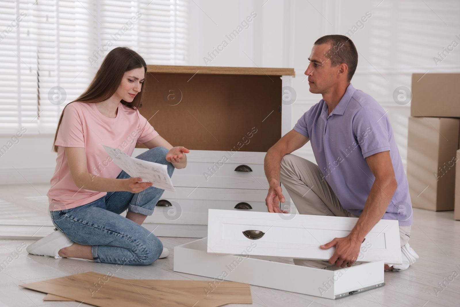 Couple with manual assembling furniture on floor at home Photo of Couple with manual assembling furniture on floor at home