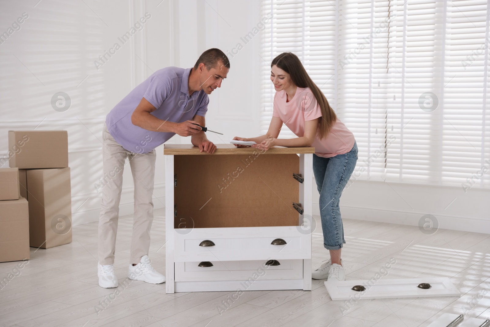 Happy couple with manual assembling furniture on floor at home Photo of Happy couple with manual assembling furniture on floor at home