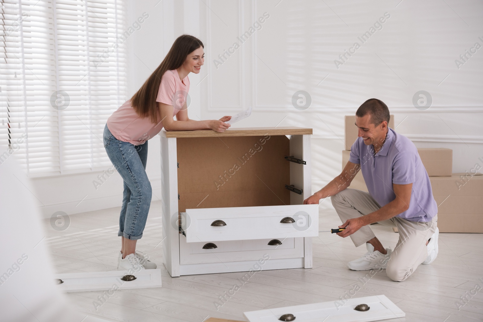 Happy couple with manual assembling furniture on floor at home Photo of Happy couple with manual assembling furniture on floor at home