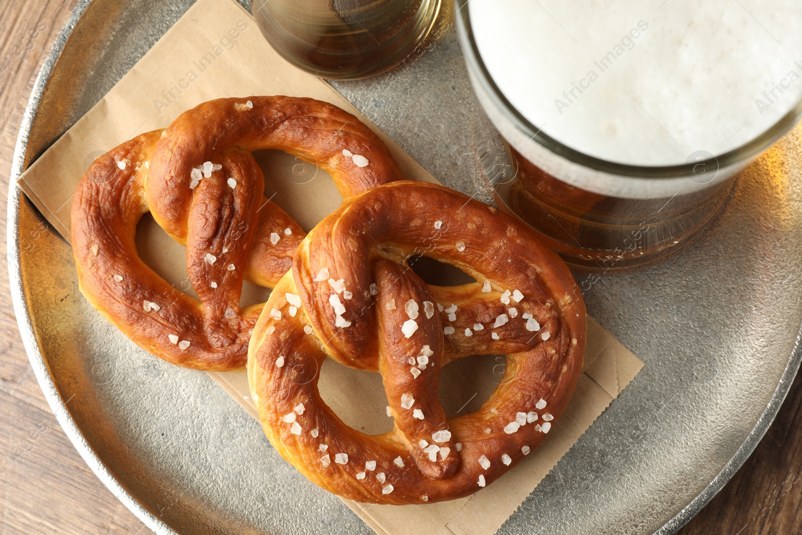 Tasty pretzels and beer on wooden table, top view Photo of Tasty pretzels and beer on wooden table, top view