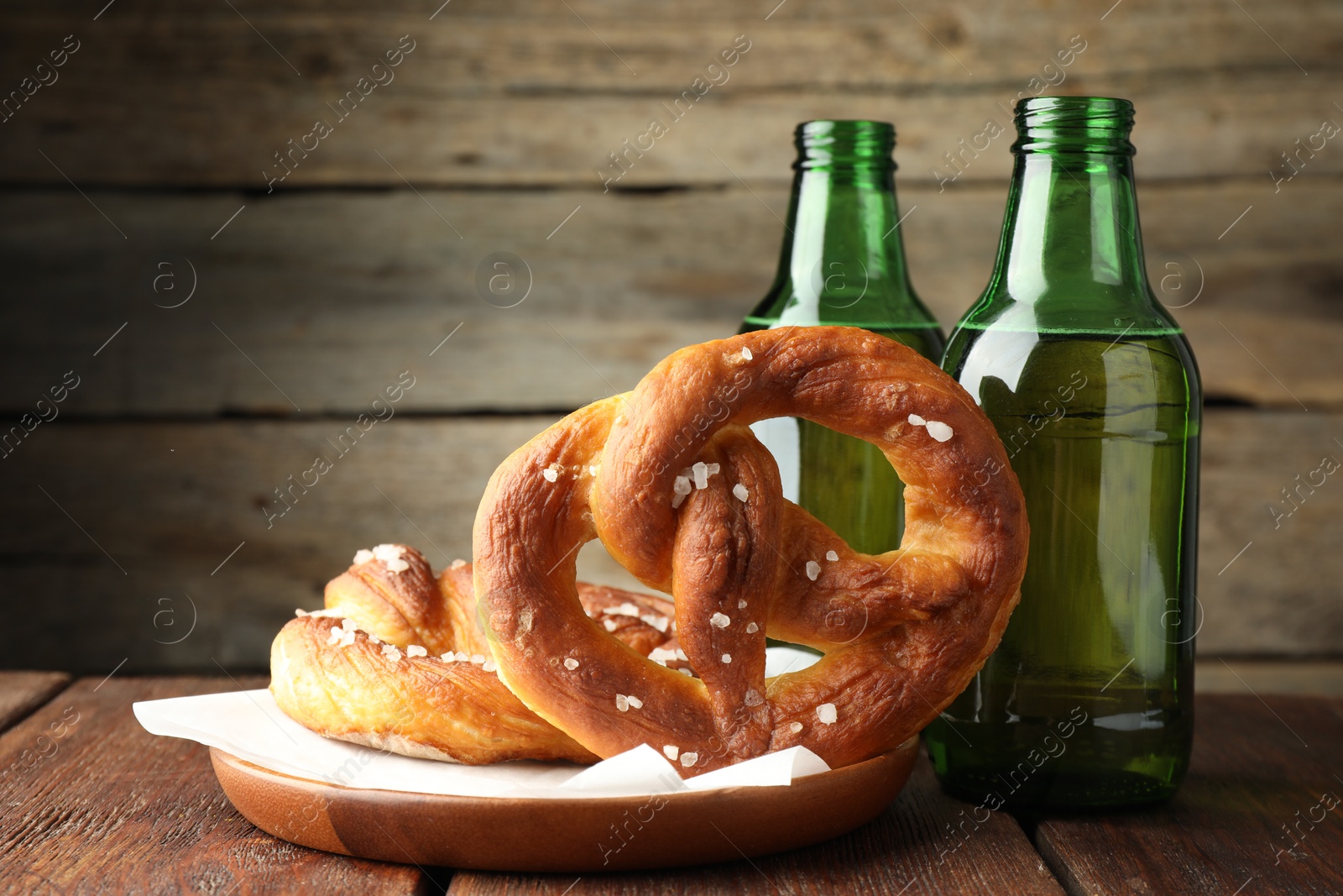 Tasty pretzels and bottles of beer on wooden table, closeup Photo of Tasty pretzels and bottles of beer on wooden table, closeup