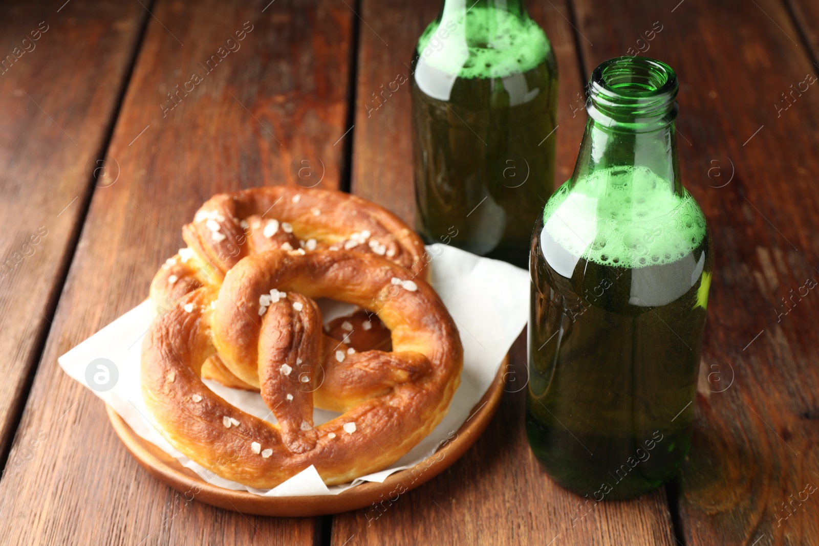 Tasty pretzels and bottles of beer on wooden table, closeup Photo of Tasty pretzels and bottles of beer on wooden table, closeup