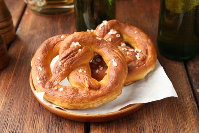 Photo of Tasty salted pretzels on wooden table, closeup
