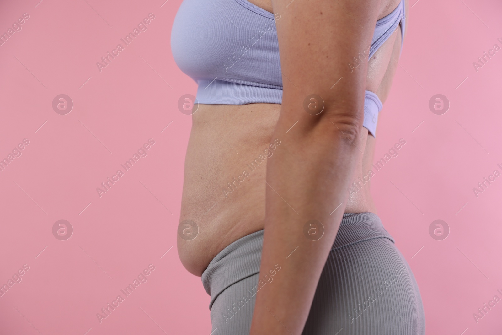 Woman with excessive belly fat on pink background, closeup. Overweight problem Photo of Woman with excessive belly fat on pink background, closeup. Overweight problem
