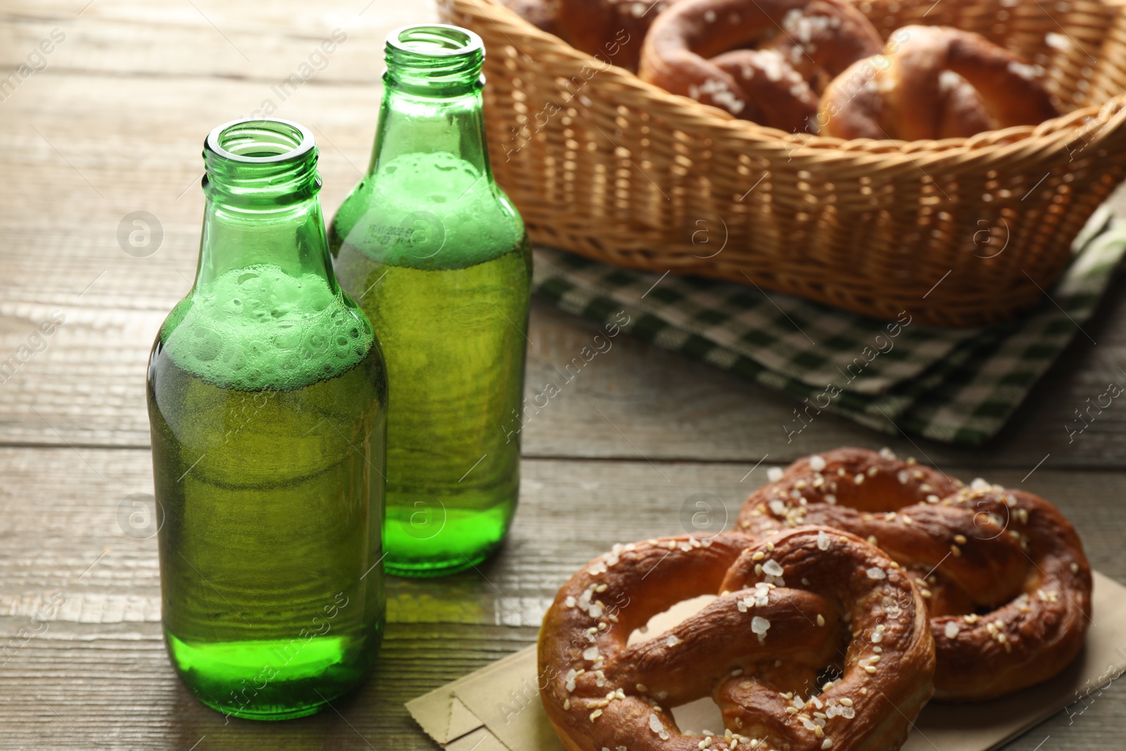 Tasty pretzels and bottles of beer on wooden table, closeup Photo of Tasty pretzels and bottles of beer on wooden table, closeup