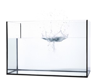 Photo of Glass aquarium with splashing water isolated on white