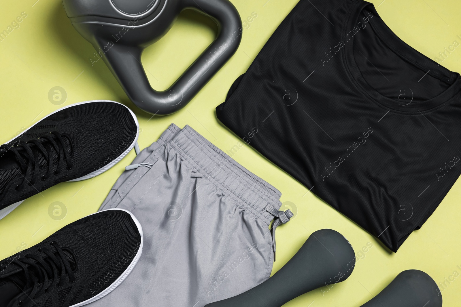 Sportswear, sneakers, dumbbells and kettlebell on pale olive background, flat lay Photo of Sportswear, sneakers, dumbbells and kettlebell on pale olive background, flat lay