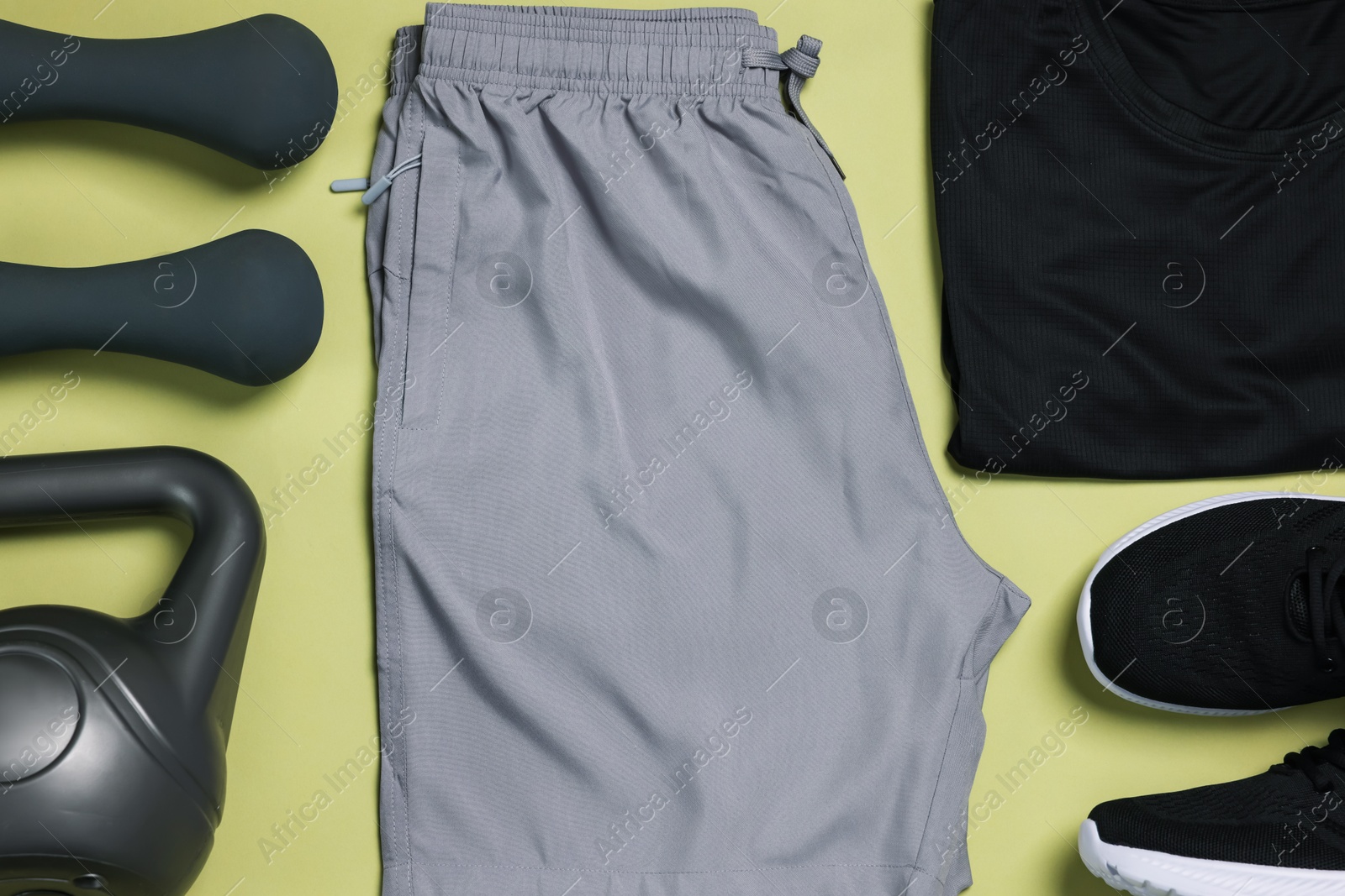 Sportswear, sneakers, dumbbells and kettlebell on pale olive background, flat lay Photo of Sportswear, sneakers, dumbbells and kettlebell on pale olive background, flat lay