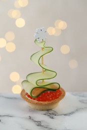 Photo of Tasty canape on white marble table against background with blurred lights, closeup. Bokeh effect