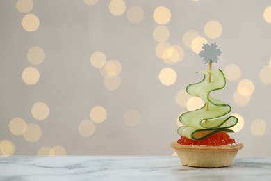 Photo of Tasty canape on white marble table against background with blurred lights, space for text. Bokeh effect