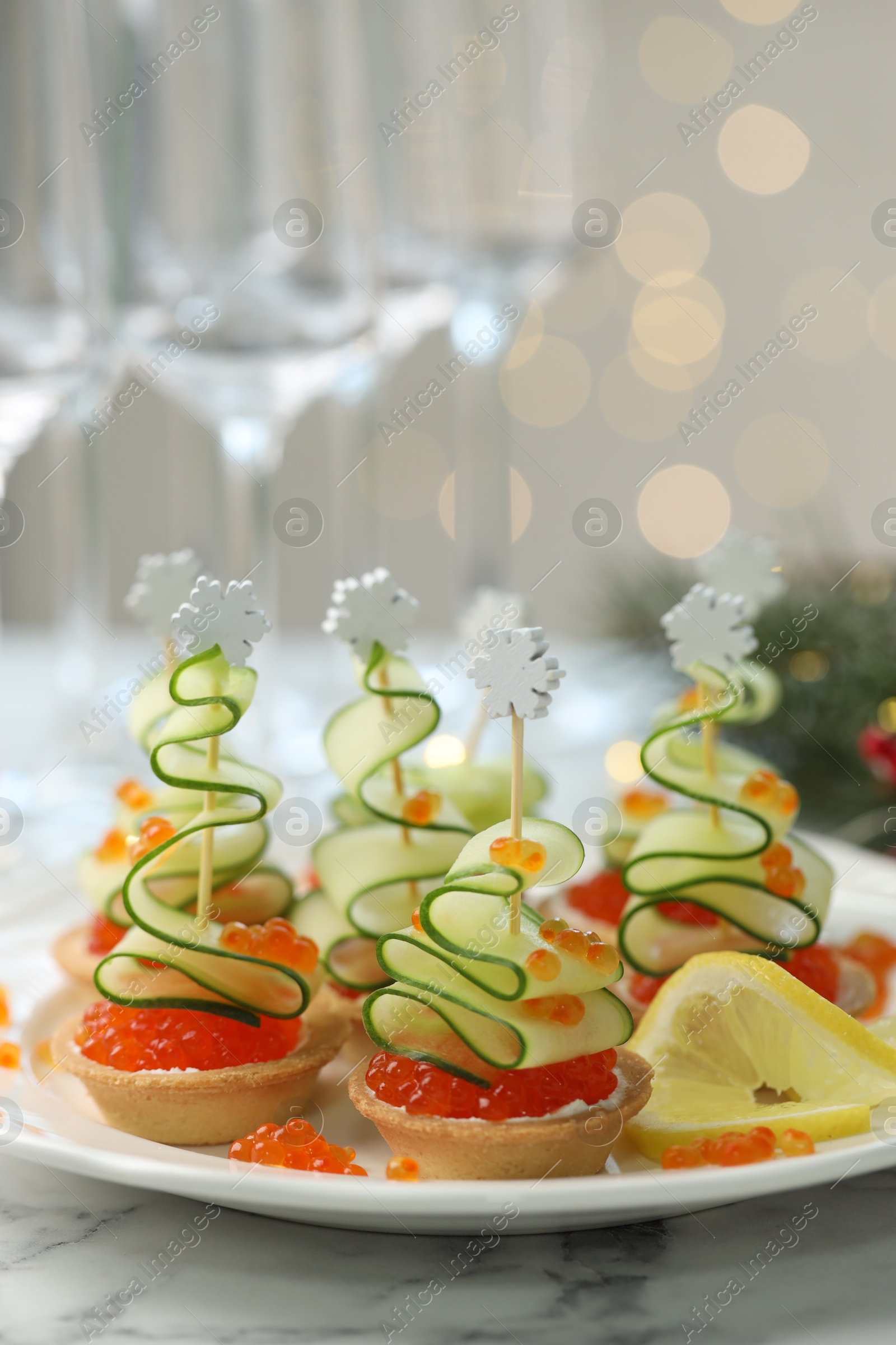 Tasty canapes on white marble table against background with blurred lights, closeup. Bokeh effect Photo of Tasty canapes on white marble table against background with blurred lights, closeup. Bokeh effect