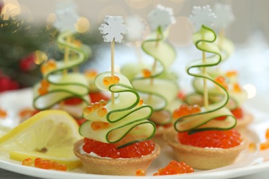 Photo of Tasty canapes on table against background with blurred lights, closeup. Bokeh effect
