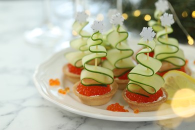 Photo of Tasty canapes and Christmas decor on white marble table, closeup