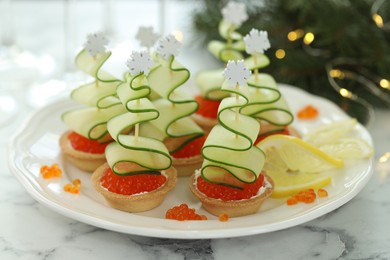Photo of Tasty canapes and Christmas decor on white marble table, closeup