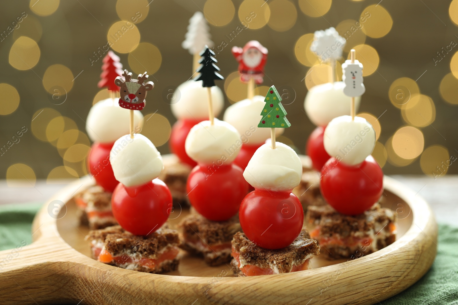 Photo of Tasty canapes on table against background with blurred lights, closeup. Bokeh effect