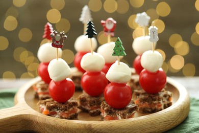 Photo of Tasty canapes on table against background with blurred lights, closeup. Bokeh effect
