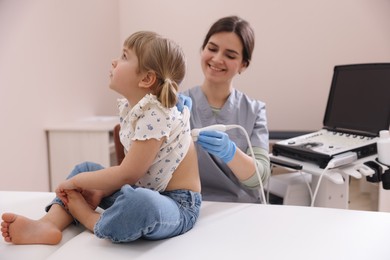 Photo of Sonographer conducting little girl's ultrasound examination in clinic