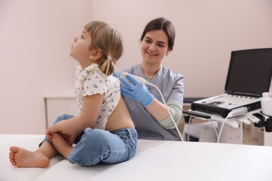 Photo of Sonographer conducting little girl's ultrasound examination in clinic