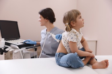 Photo of Sonographer conducting little girl's ultrasound examination in clinic