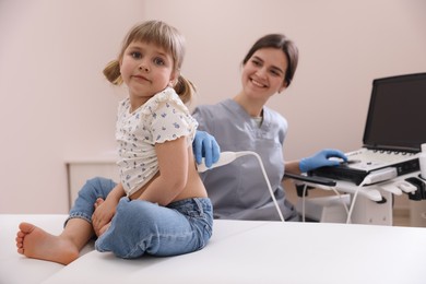 Photo of Sonographer conducting little girl's renal ultrasound examination in clinic