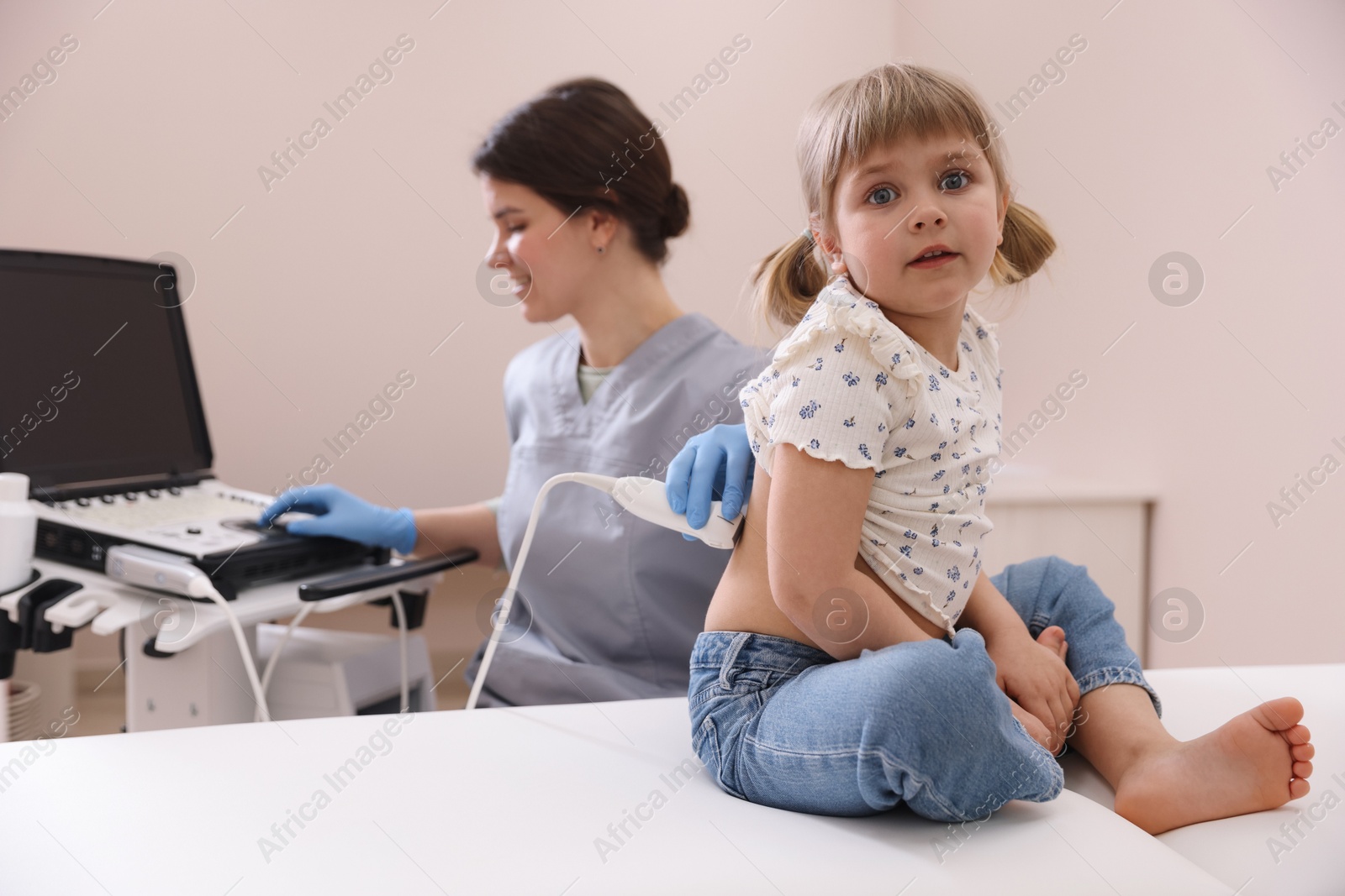 Sonographer conducting little girl's renal ultrasound examination in clinic Photo of Sonographer conducting little girl's renal ultrasound examination in clinic