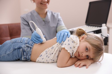 Photo of Sonographer conducting little girl's renal ultrasound examination in clinic, closeup