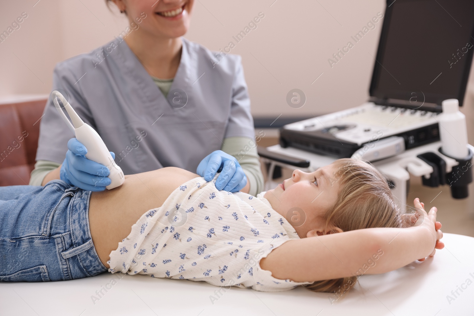 Sonographer conducting little girl's abdominal ultrasound examination in clinic, closeup Photo of Sonographer conducting little girl's abdominal ultrasound examination in clinic, closeup