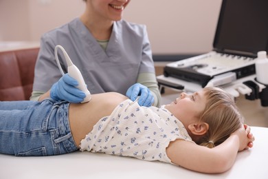 Photo of Sonographer conducting little girl's abdominal ultrasound examination in clinic, closeup