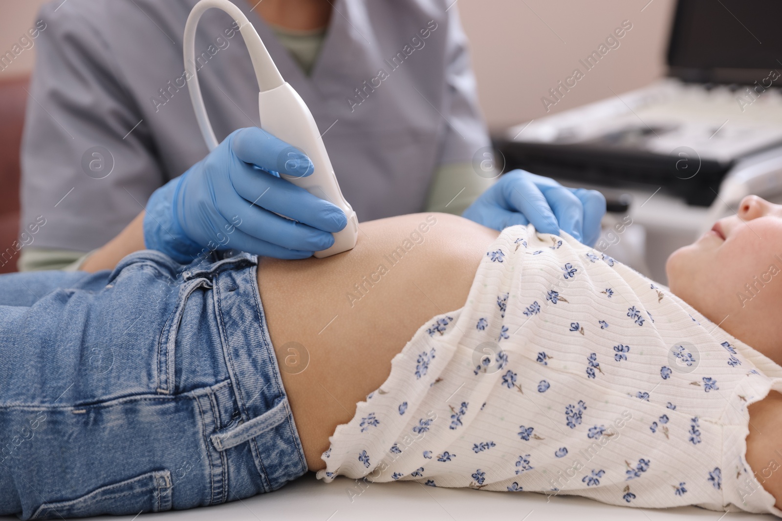 Sonographer conducting little girl's abdominal ultrasound examination in clinic, closeup Photo of Sonographer conducting little girl's abdominal ultrasound examination in clinic, closeup