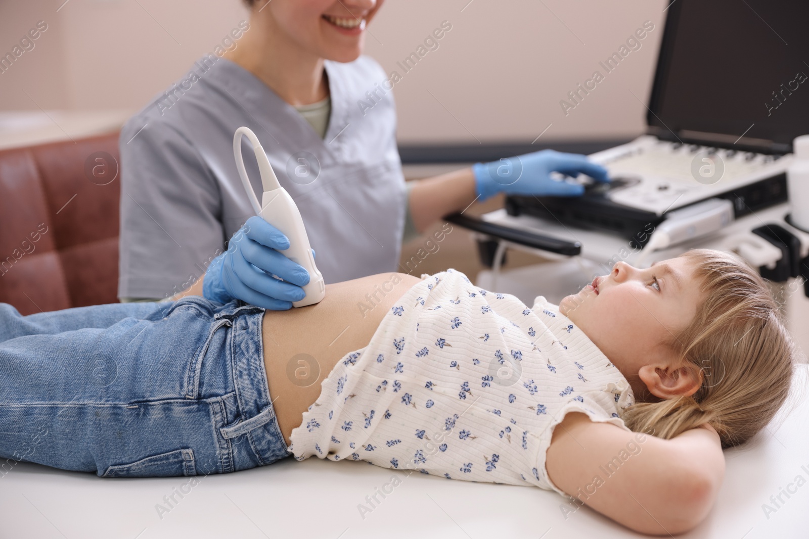 Sonographer conducting little girl's abdominal ultrasound examination in clinic, closeup Photo of Sonographer conducting little girl's abdominal ultrasound examination in clinic, closeup