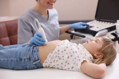 Photo of Sonographer conducting little girl's abdominal ultrasound examination in clinic, closeup