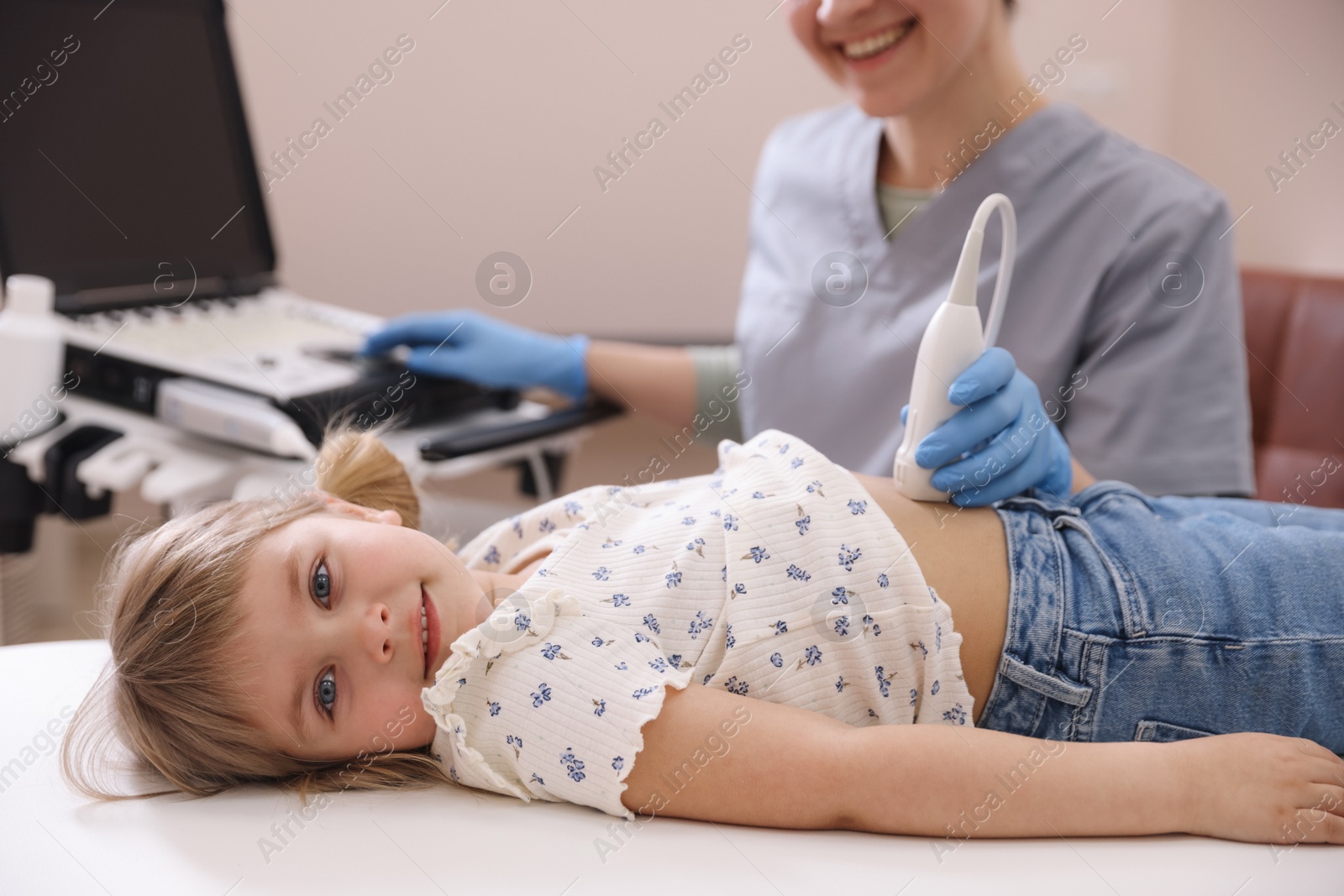 Sonographer conducting little girl's abdominal ultrasound examination in clinic, closeup Photo of Sonographer conducting little girl's abdominal ultrasound examination in clinic, closeup