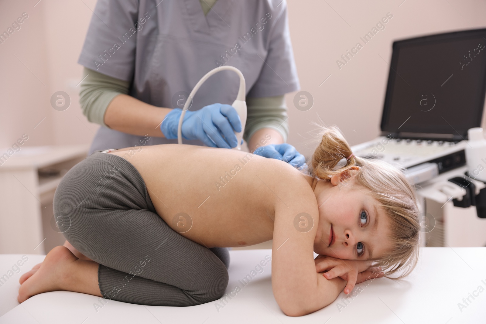 Sonographer conducting little girl's ultrasound examination in clinic, closeup Photo of Sonographer conducting little girl's ultrasound examination in clinic, closeup