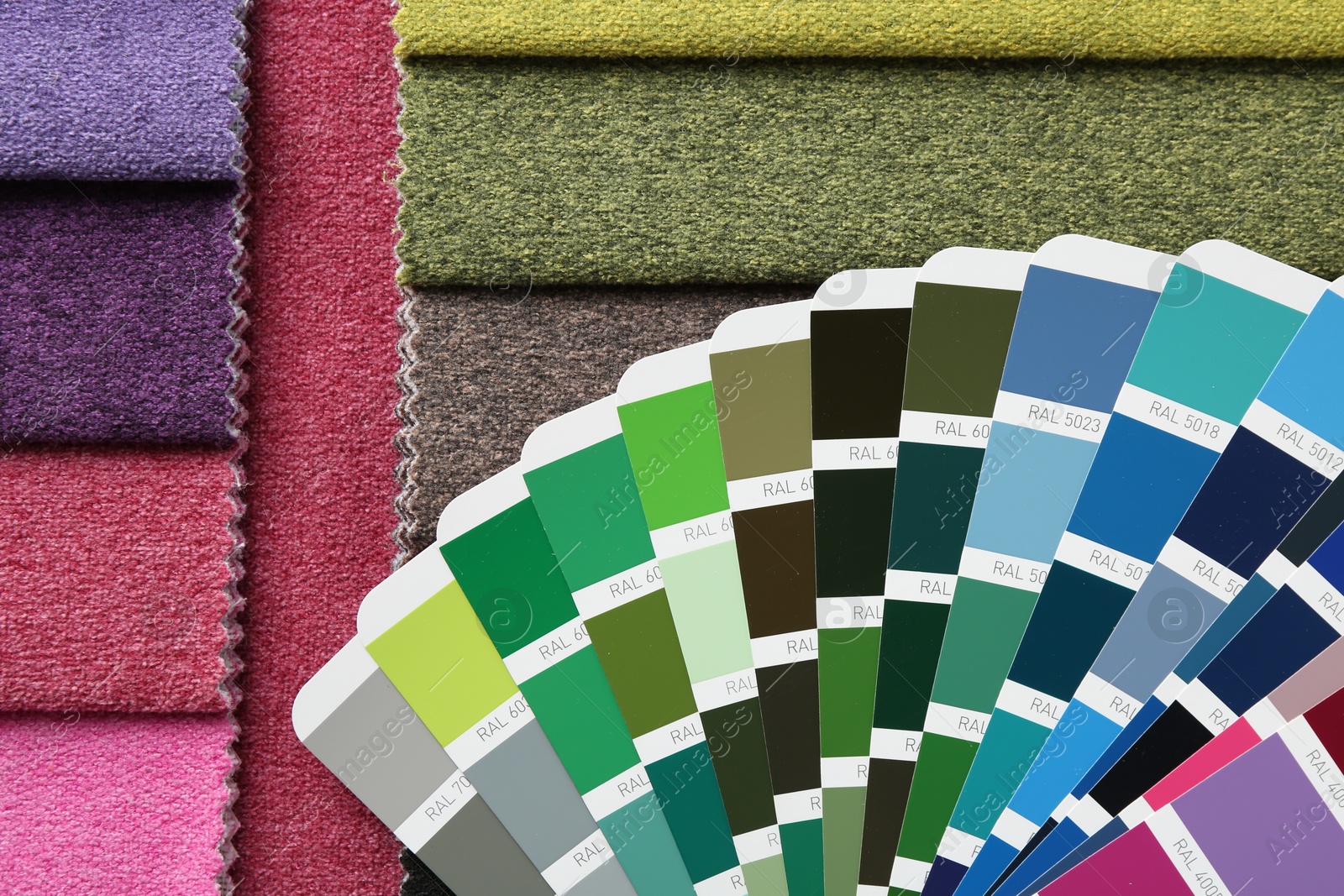 Photo of Samples of colorful fabrics and color palettes, top view