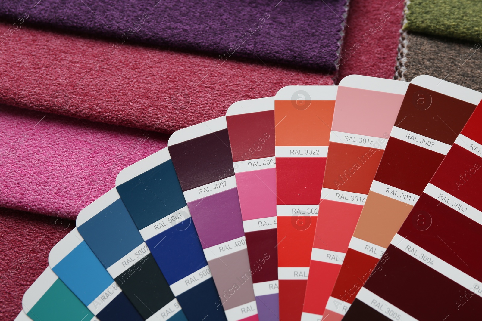 Photo of Samples of colorful fabrics and color palettes, above view